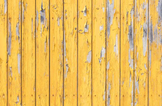 Old yellow wooden wall background texture with peeling paint