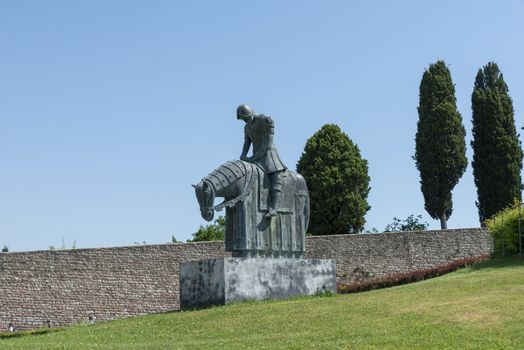 assisi,italy july 11 2020 :monument of a man on horseback placed in the garden in front of the basilica of san francesco di assisi