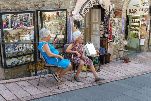 assisi,italy july 11 2020:elderly couple sitting in a street of Assisi