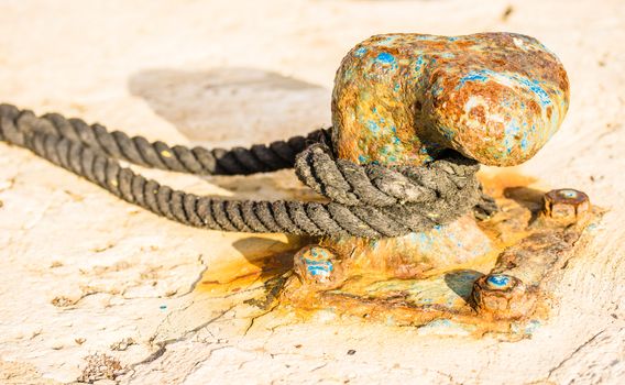 Close-up, of old rusty mooring bollard at pier