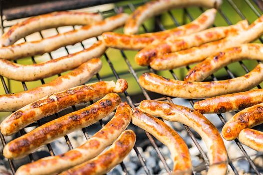 Grilled sausages on barbecue grill, close-up