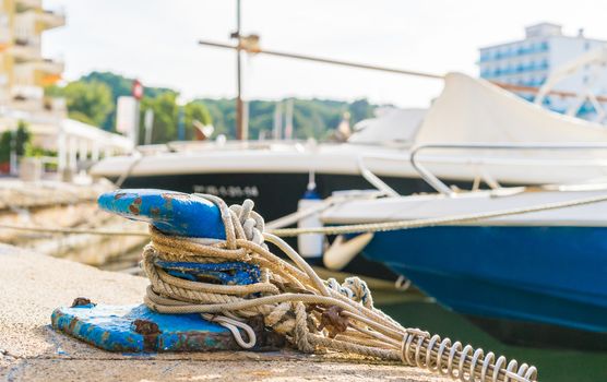 Close-up of mooring bollard with moored ropes