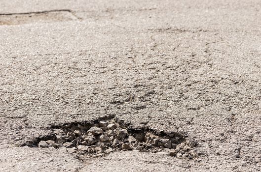 Close-up of damaged street with pot hole