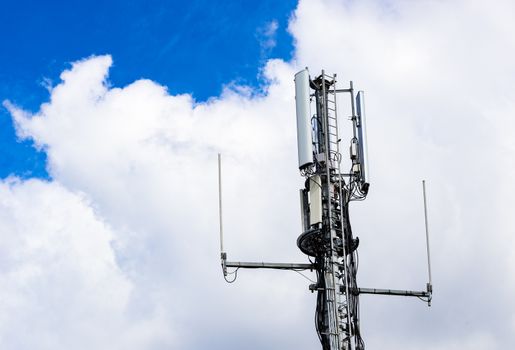 Detail view of telecommunication tower with cloudy sky background