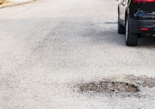 Close-up of damaged street with pot hole