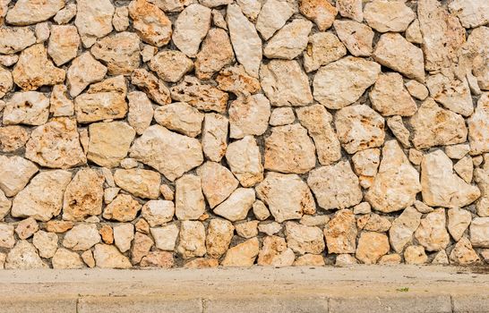 Rustic old stone wall texture background with pavement