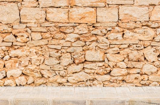 Vintage stone wall background texture with pavement