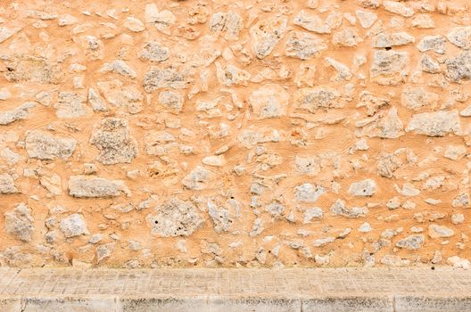 Vintage stone wall texture background with pavement

