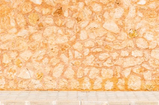 Rustic stone wall background texture with sidewalk