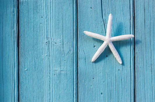 Starfish on blue wooden background for summer holiday concept