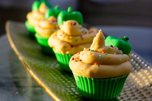 Delicious looking cupcake sot aps with green base and yellow lemon cream colorful sprinkles shot in golden sunrise light. Shows beautiful clean soap as a hobby or a home business for SLS free, paraben free artisanal handmade soaps