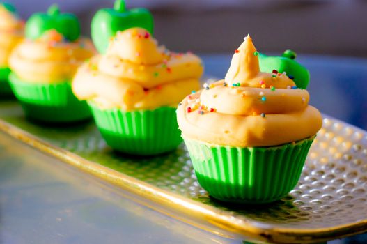 Delicious looking cupcake sot aps with green base and yellow lemon cream colorful sprinkles shot in golden sunrise light. Shows beautiful clean soap as a hobby or a home business for SLS free, paraben free artisanal handmade soaps