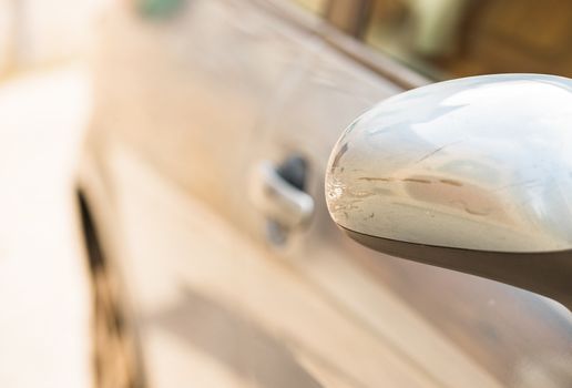 Car side-view mirror after crash with scratched silver paint