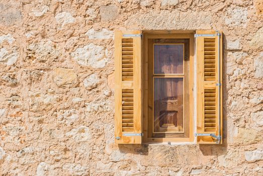 Open wooden brown window shutters and stone wall background