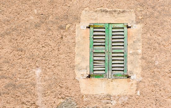 Detail view of antique wooden window shutters and rustic old wall