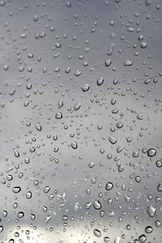 Abstract background, water drops on a window glass, rainy day