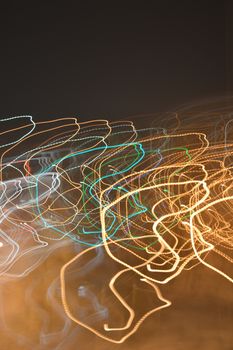 Abstract background, color lights into motion over dark. Shallow dof