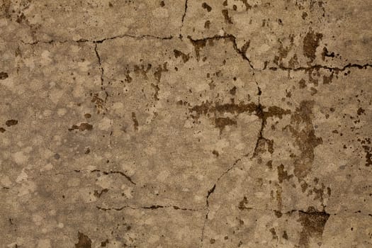 Old mottled brown cracked stone wall distressed grunge texture background 