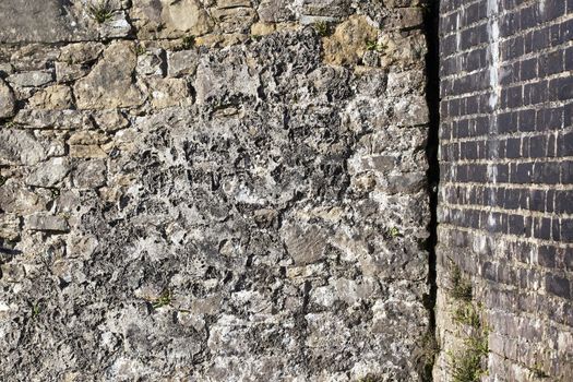 Old large weathered distressed concrete covered red brick wall texture background