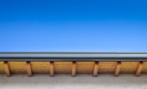 New roof top detail with copper water gutter, against blue skies.