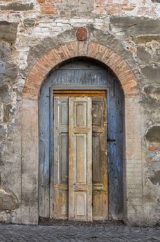 Grungy old locked door painted with yellow and blue paint. Amazing medieval time.