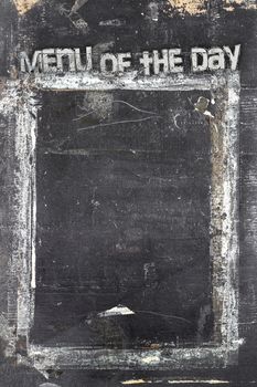 Blackboard in grunge style, scratched and ruined, with message "Menu of the day".