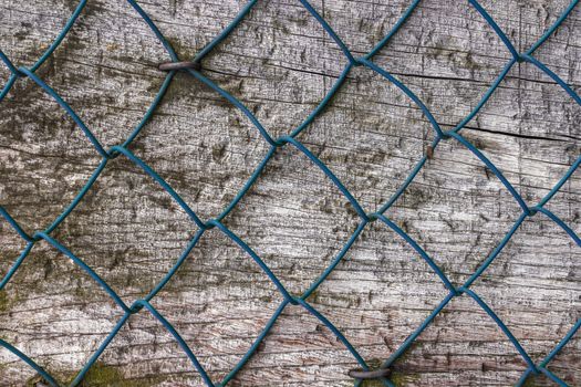Diamond fence nailed on wood panel.