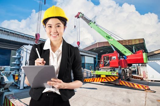 Young woman engineer holding digital tablet wtih smile in construction site background