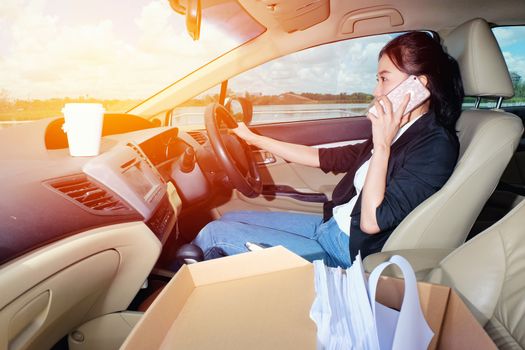 Young woman talking her mobile phone. in the car.