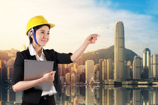 Young woman engineer holding digital tablet wtih smile in daylight cityscape background