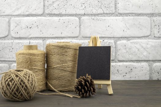 Assorted balls of hemp twine and slate chalkboard in a close up rustic still life