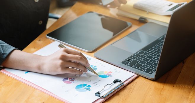 Closeup Business adviser analyzing financial figures denoting the progress at office.