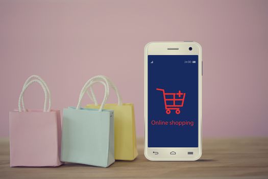Shopping Online and e-commerce concept: paper shopping bags with smartphone on table. Online stores are considered as another medium of trading goods between entrepreneurs and customers.