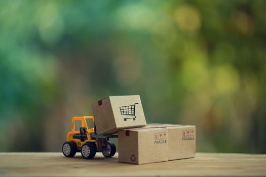 Logistic and cargo freight concept: Fork-lift truck moves a pallet with Paper boxes. depicts delivery management from the point of origin to point of consumption according to needs of customers