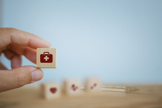 Medical treatment / Operating system / Healthcare concept: Hand chooses wooden cube blocks with icon on table. Depicts responsibility for self-health in nutrition to ensure integrity Without illness.