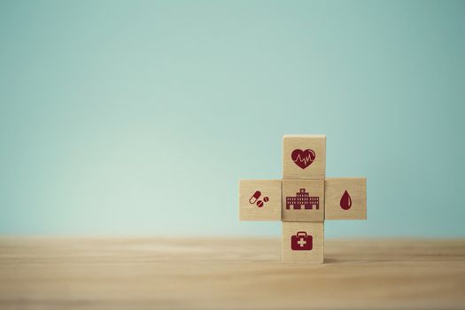 Healthcare concept about of health and medical insurance, arranging wood block stacking with icon healthcare medical on table wooden background.