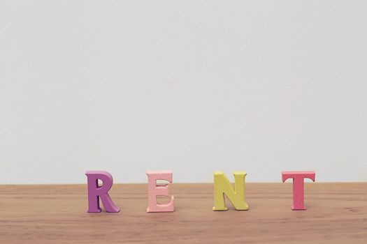 Creative idea of arrange the letters of word "RENT" on table. Buying a right to temporarily own something this right means being able to make full use of rented items.