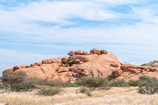 People are visible at a granite rock formation, resembling a broken arrow, at the greater Spitzkoppe