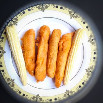 Delicious hot Baby corn baji with fresh baby corn placed in plate with black backgrounds and packed with vital antioxidants and has essential fibres