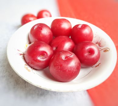 Colorful Red plums kept in bowl placed in red and white backgrounds and reduce the risk of cancer heart disease and diabetes