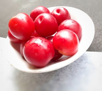 Colorful Red plums kept in bowl placed in black and white backgrounds and reduce the risk of cancer heart disease and diabetes