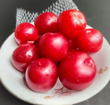 Colorful Red plums kept in bowl placed in black backgrounds and reduce the risk of cancer heart disease and diabetes