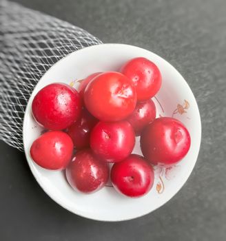 Colorful Red plums kept in bowl placed in black backgrounds and reduce the risk of cancer heart disease and diabetes