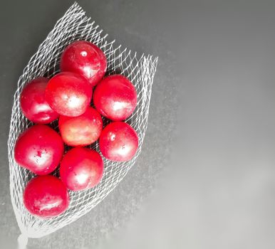 Colorful Red plums kept in fruit cover placed in black background and reduce the risk of cancer heart disease and diabetes