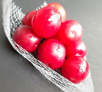 Colorful Red plums kept in fruit cover placed in black background and reduce the risk of cancer heart disease and diabetes