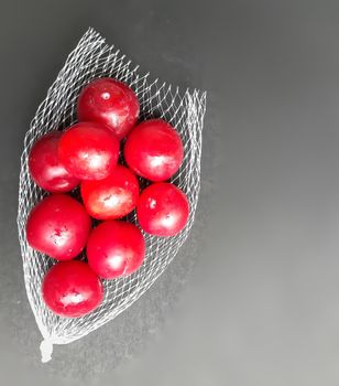 Colorful Red plums kept in fruit cover placed in black background and reduce the risk of cancer heart disease and diabetes