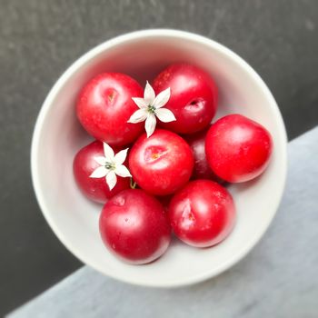 Colorful Red plums kept in bowl placed in white and black background and reduce the risk of cancer heart disease and diabetes