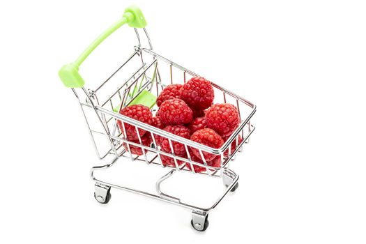 Fresh raspberries in miniature shopping cart. Isolated on white background.