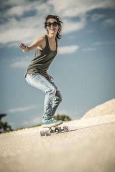 Young woman down the road with a skateboard