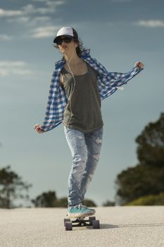 Young woman down the road with a skateboard